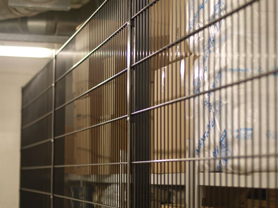 Twin wire mesh panels fitted inside a factory to secure a stores area