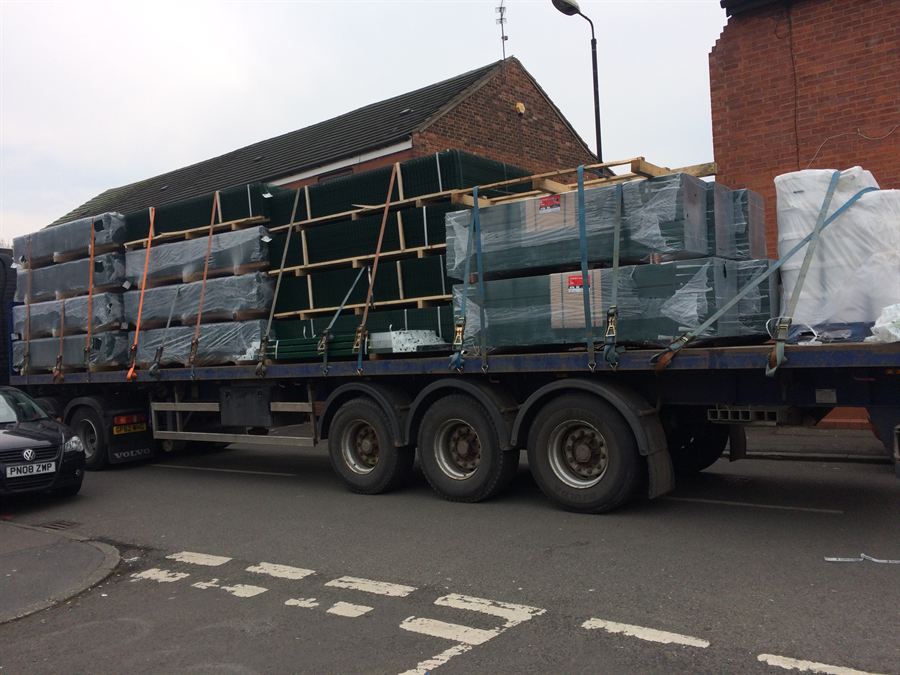 Palletised fencing materials loaded on a flatbed lorry for delivery to site