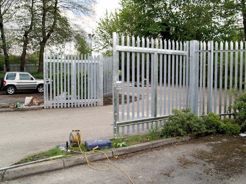 Galvanised palisade double gates and fencing at a site entrance